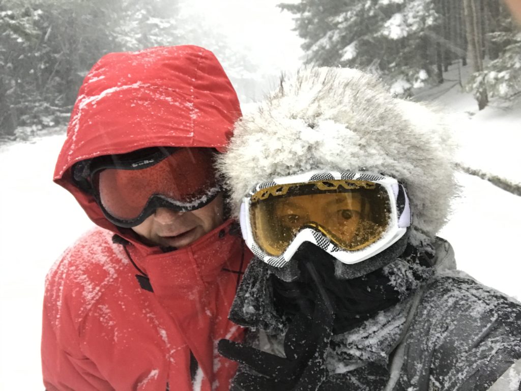 man and woman in blizzard wearing goggles